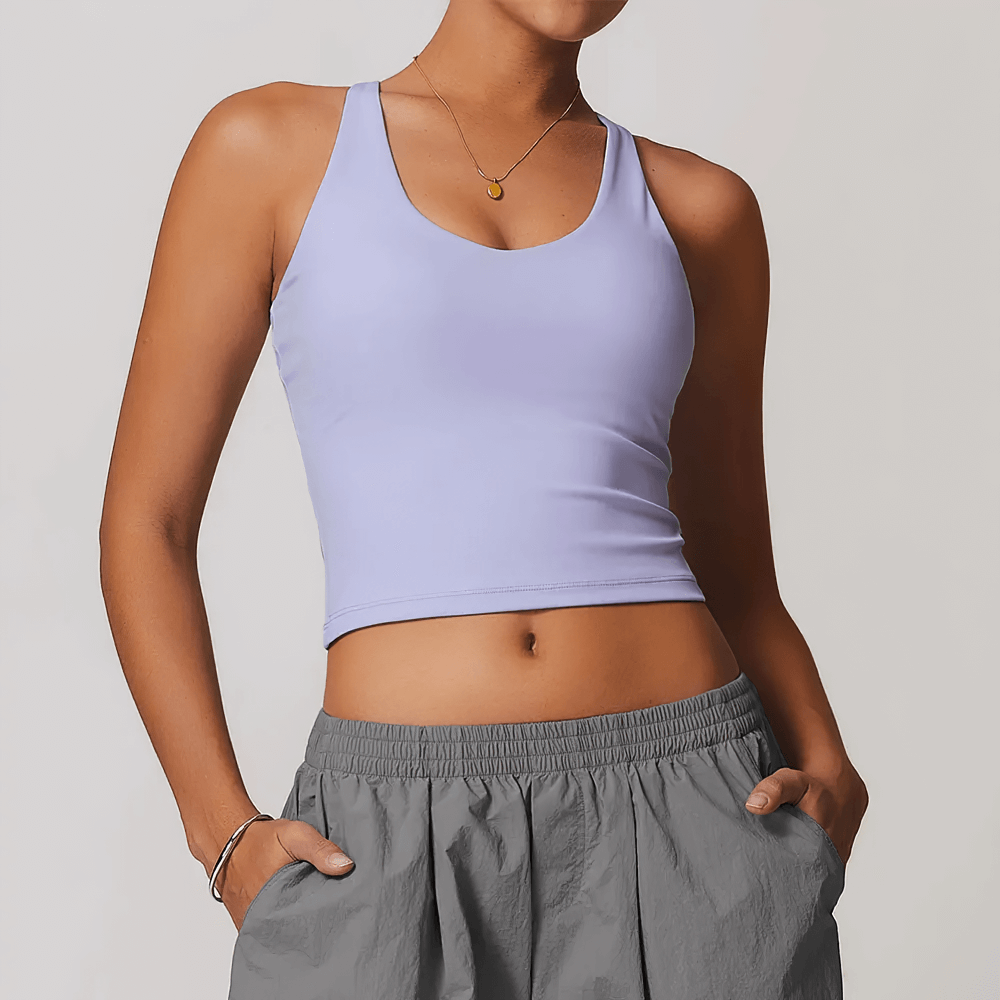 Woman wearing lavender cross-back yoga tank top, perfect for running, dance, gym, and fitness. Breathable fabric for active lifestyle.